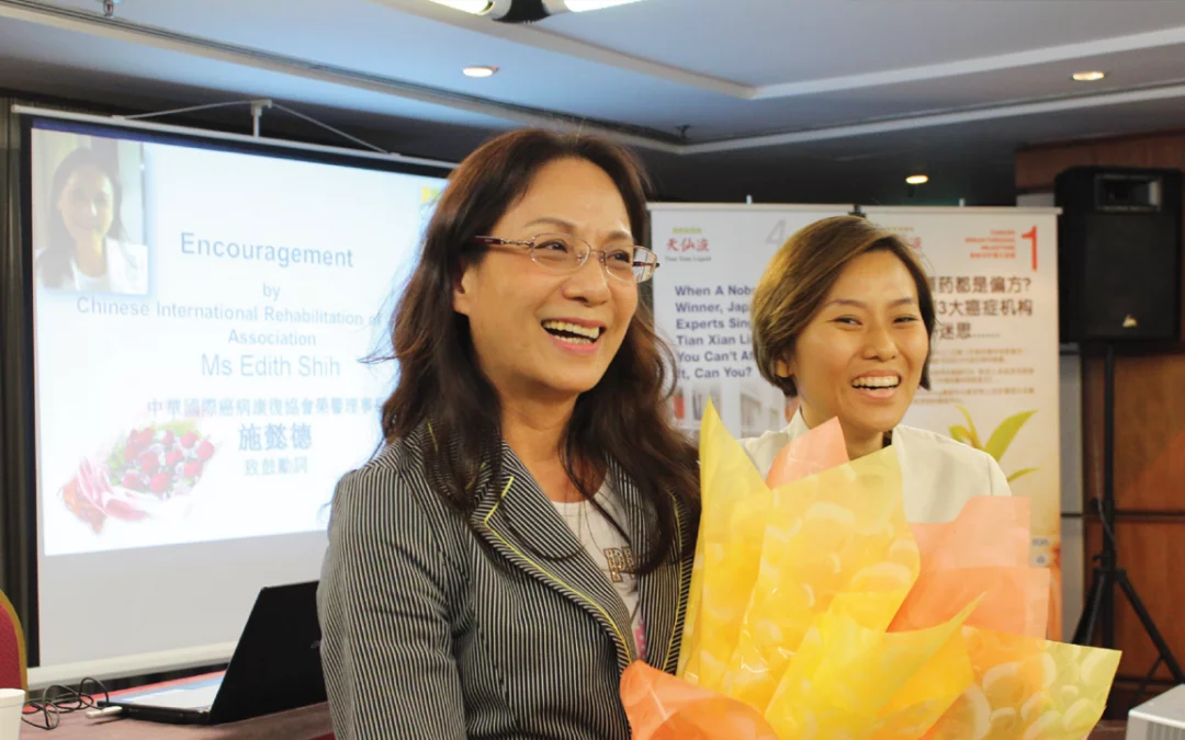 A smiling woman, Mrs. Shi from Taiwan, stands confidently outdoors, symbolizing strength and resilience as a breast and cervical cancer survivor.